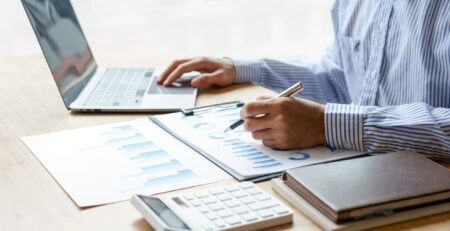 Close up hands of business man using a calculator to calculate e