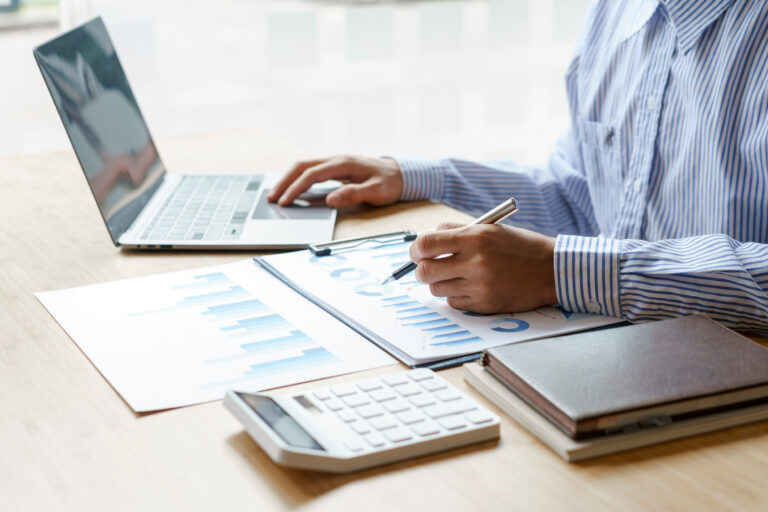 Close up hands of business man using a calculator to calculate e