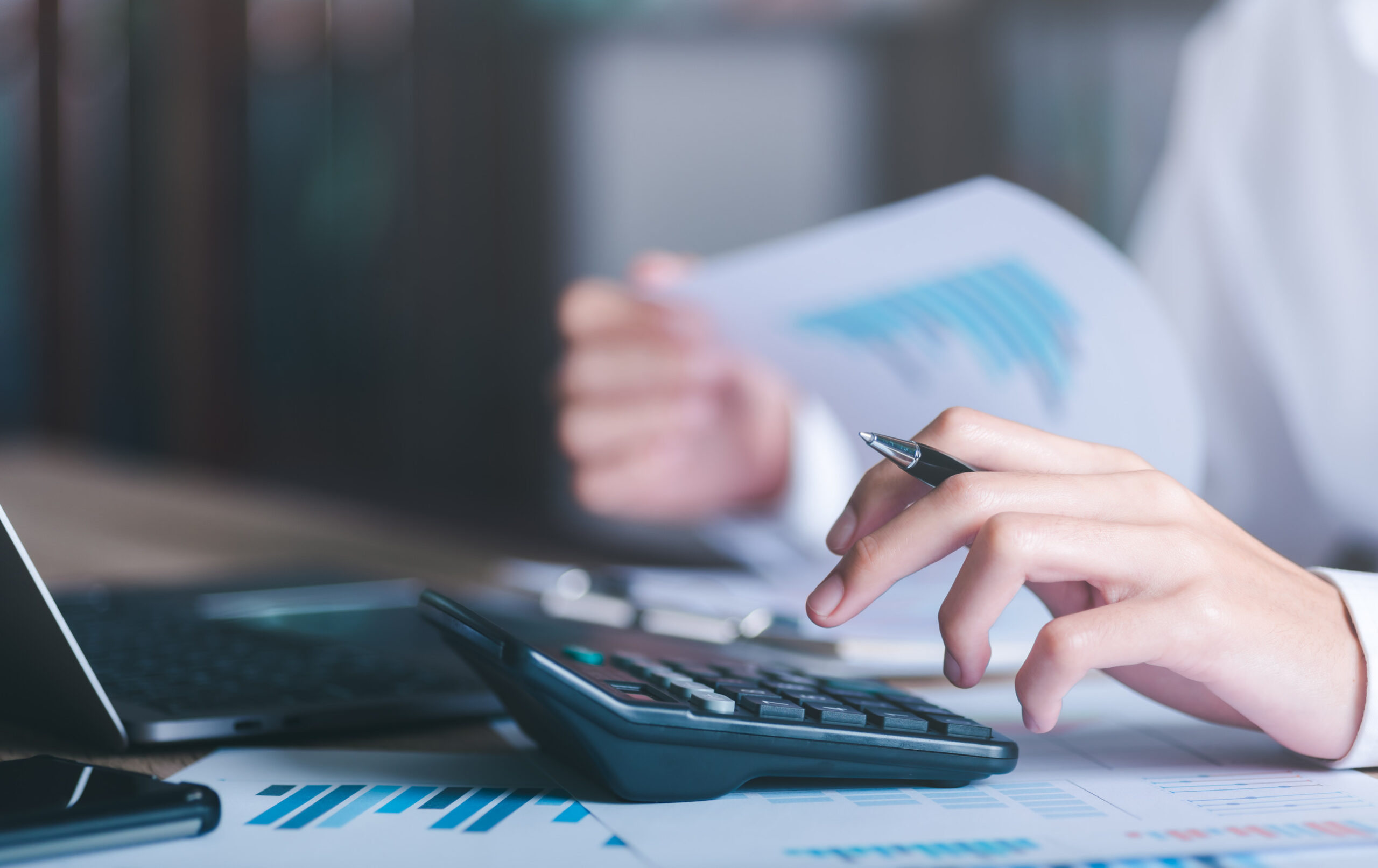 Businessman calculating figures in company financial documents w
