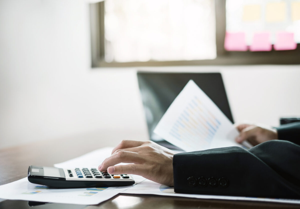 The businessman hand sits at their desks and calculates financia